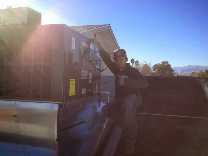 HVAC technician performing Air Duct Cleaning on a rooftop unit in Eustis